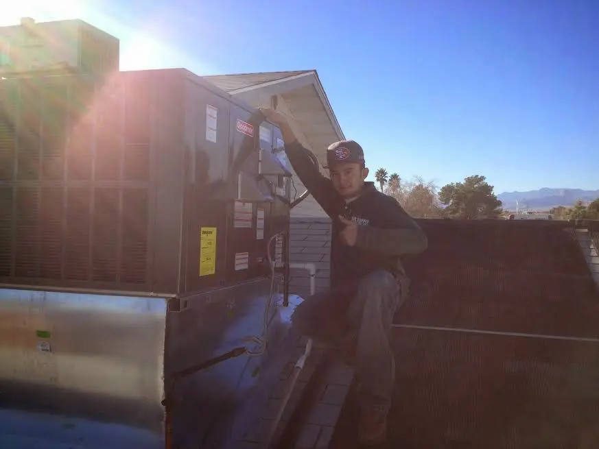 HVAC technician performing Air Duct Repair on a rooftop unit in Forrest City